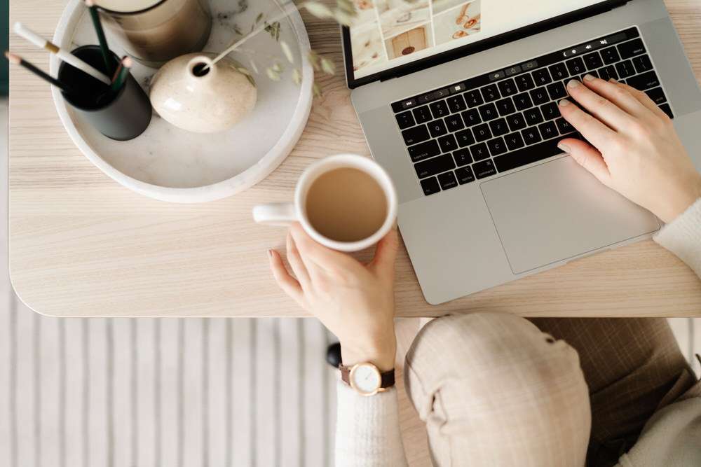 Person working on laptop with coffee